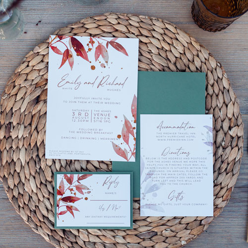 orange wedding invitation suite on natural wicker placemat