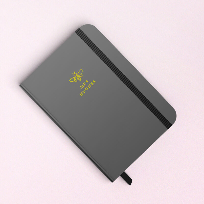 black notebook with bee and name