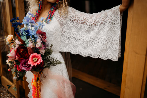 boho bride with floaty wedding dress and colourful dried wedding flowers